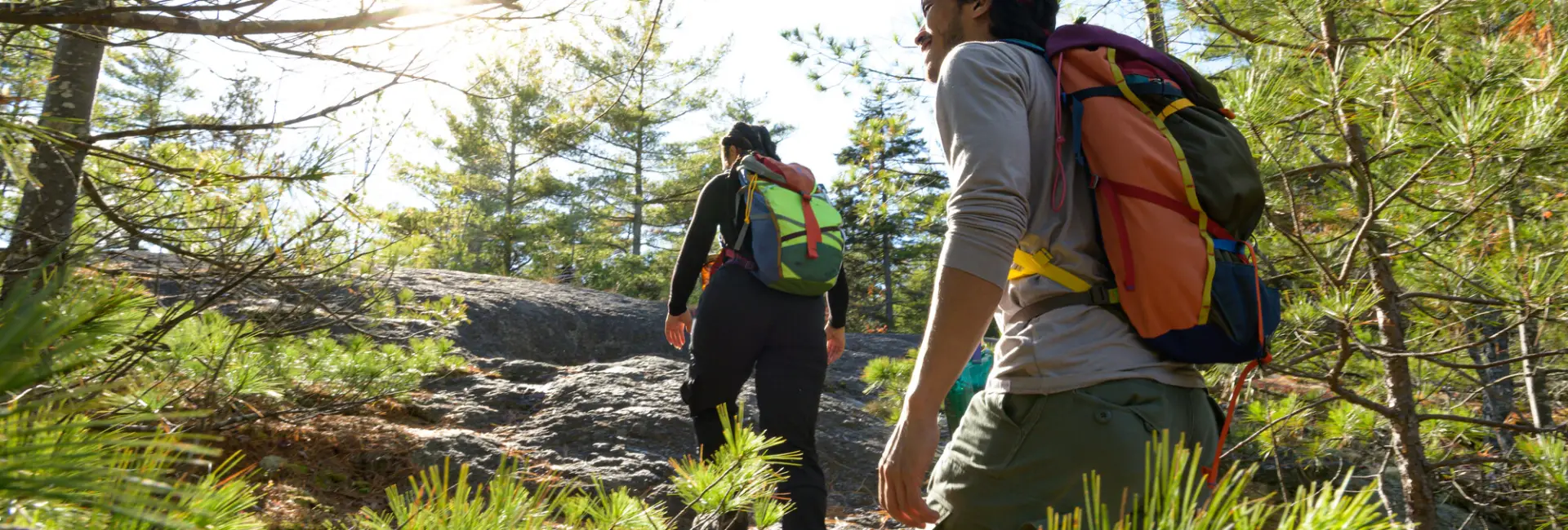 A man and woman climb a mountain. 