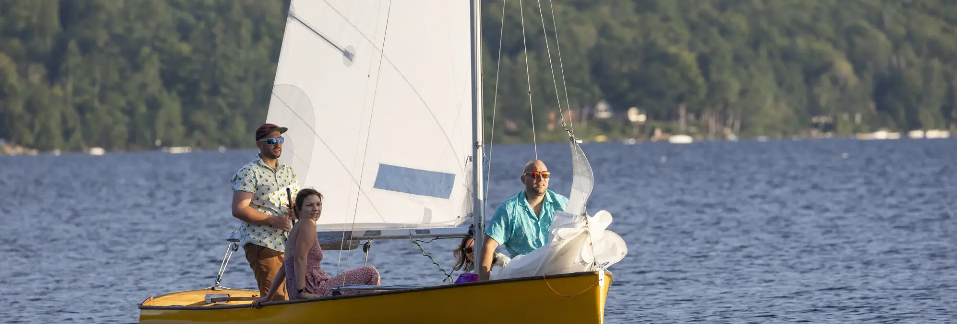 A family sails on a sailboat on a lake. 