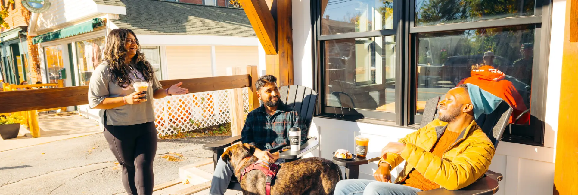 three friends share coffee together at a coffee shop. 