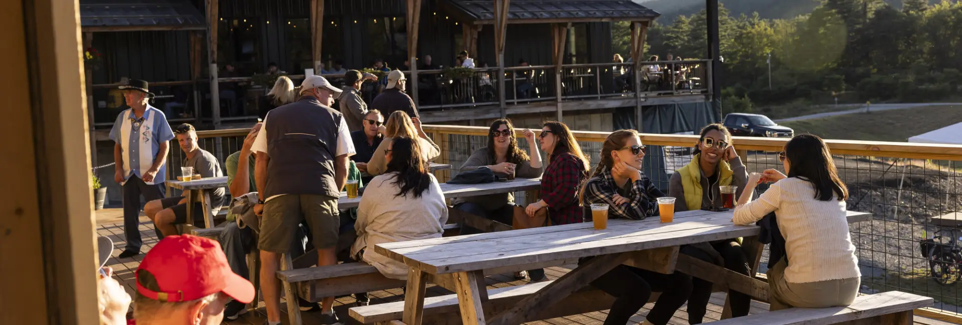 A group of people have drinks on the patio of a brewery.