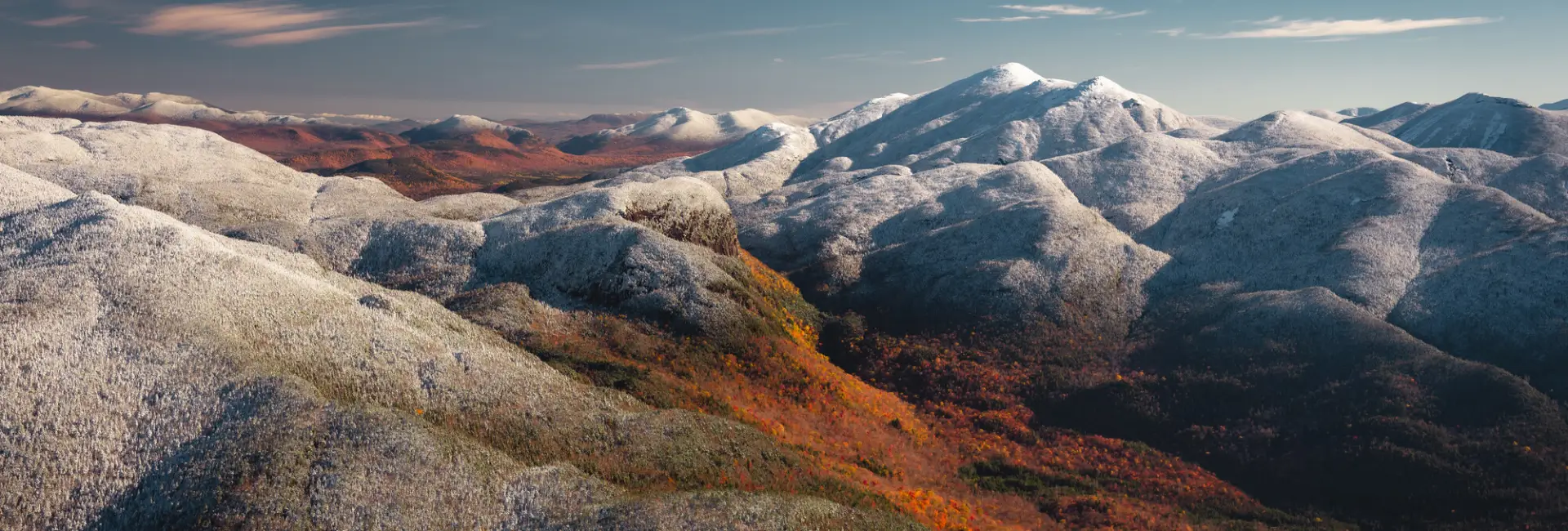 A mountain range in fall with frosted whitecaps. 