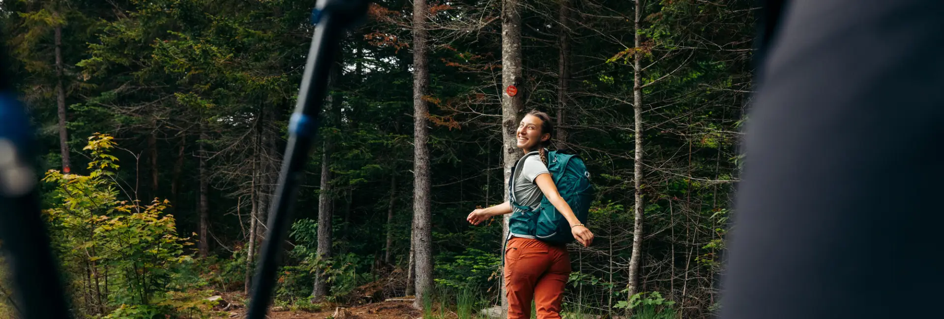 A woman walks away from the camera on a nature trail.