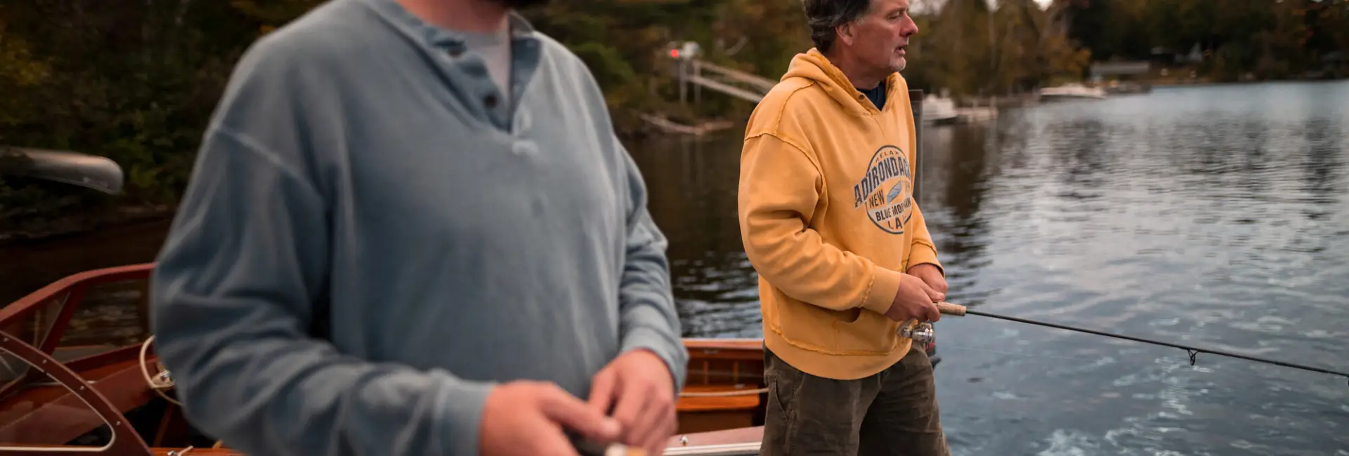 Two men fish together on a lake. 