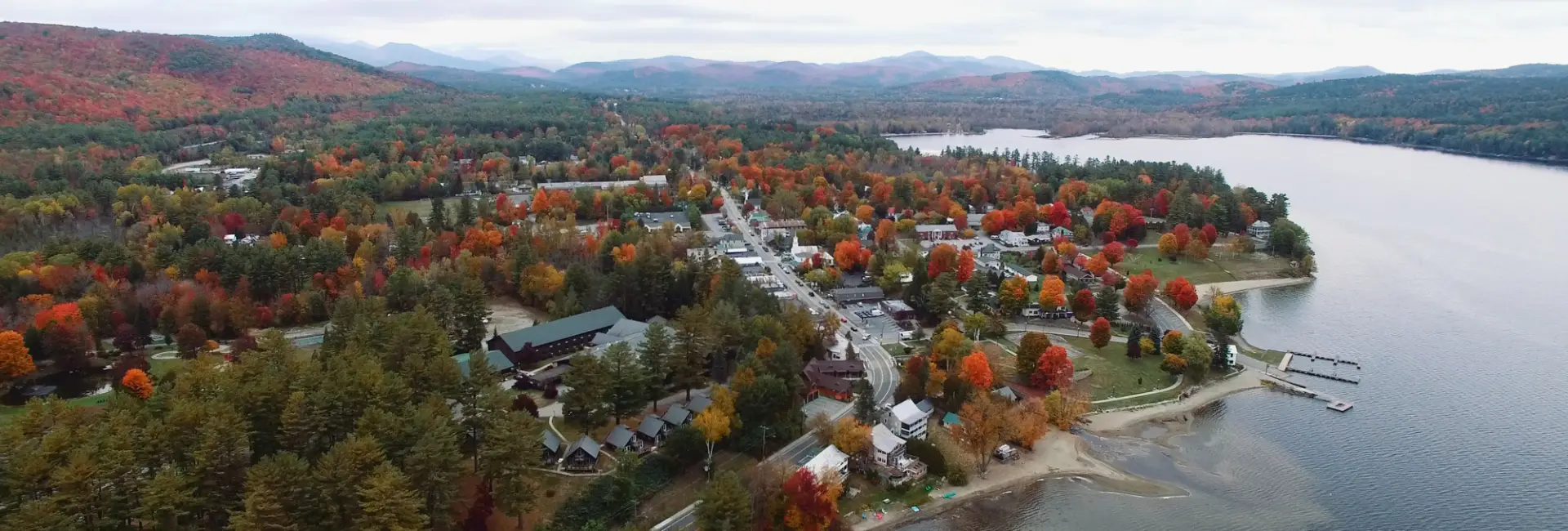 A lakeshore in fall lined with homes.