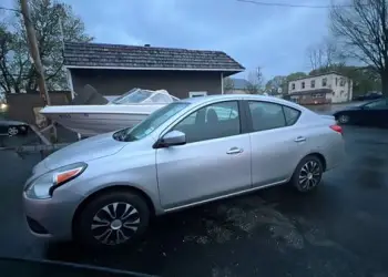 A silver 2019 Nissan Versa available for taxi rides
