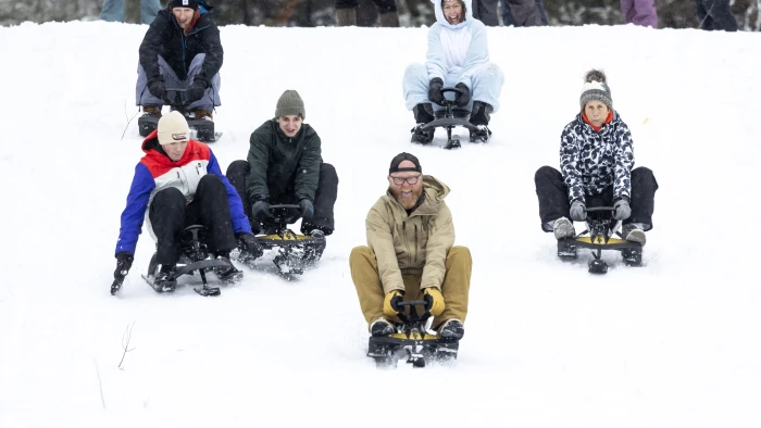 A large group of people who attended last year's carnival posing for a photo with cardboard sleds in front