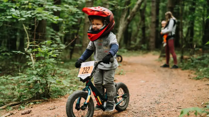 Small child on small mountain bike with full face red helmet