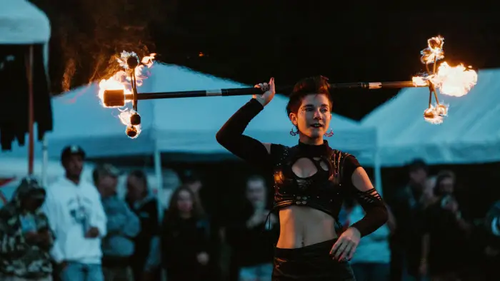 Smoke show fire dancer twirls double-ended fire baton