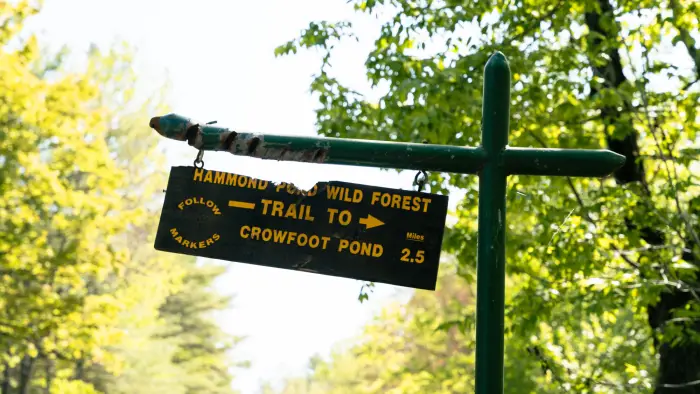 A wooden sign for Crowfoot Pond