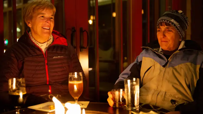 People enjoying cocktails by a fire for the Lake Placid Film Festival.