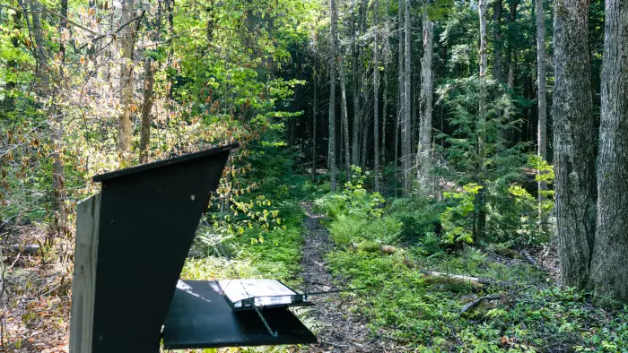 A wooden sign in register for a hike