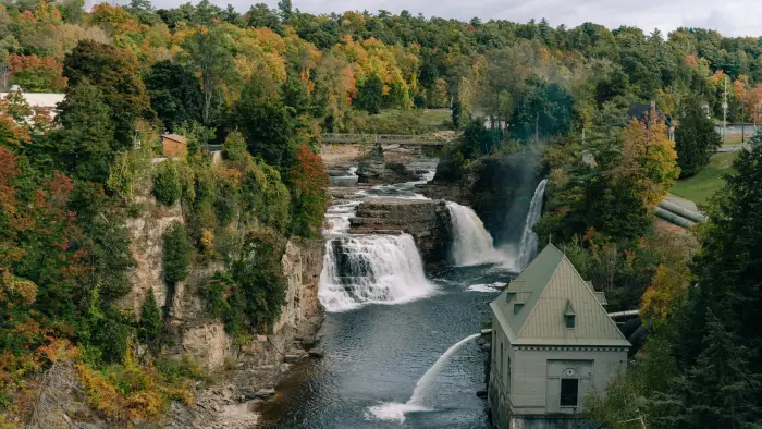 Water crashes over the falls with a building near by