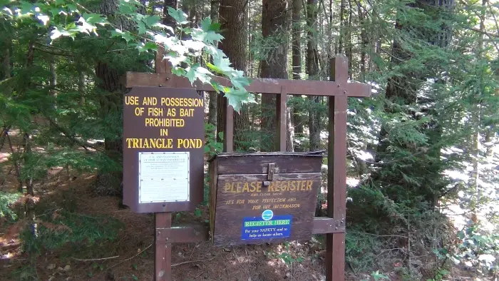 A yellow and brown trail register station.