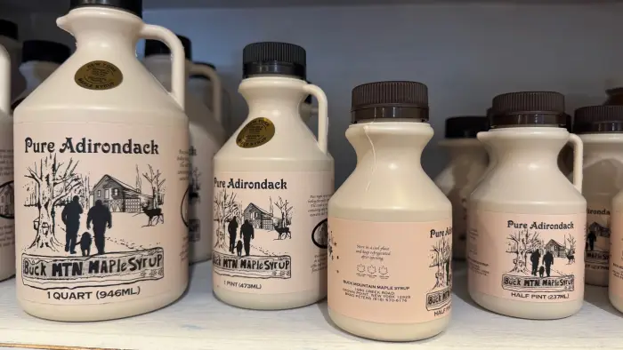 A long walk way of refrigerated coolers filled with beverages and shelves with snacks