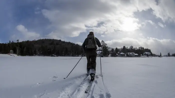 a person cross country skiing across the lake