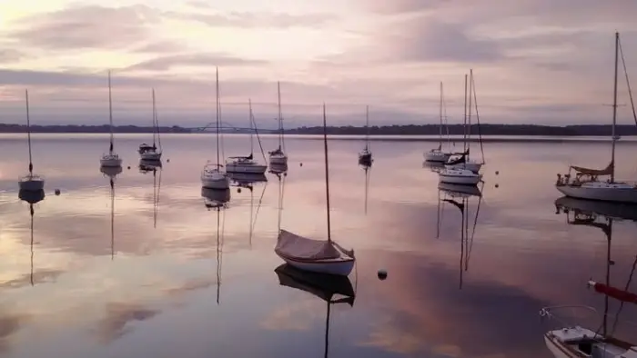 moored sailboats agains pink evening sky