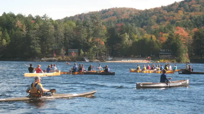 several long boats off the shore of long lake beach paddling in the long boat regatta
