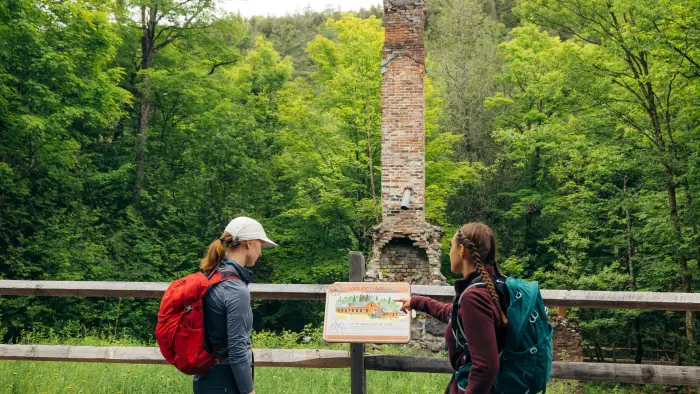 Two hikers at a historic site along the Calamity Brook Trail at Upper Works