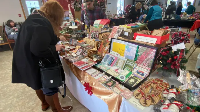 Woman browsing holiday gifts at a craft fair. 