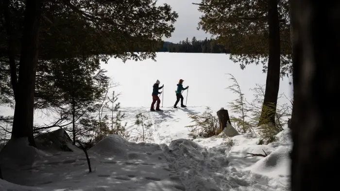 Two skiers on the frozen Big Pond in the Hoffman Notch Wilderness Area.