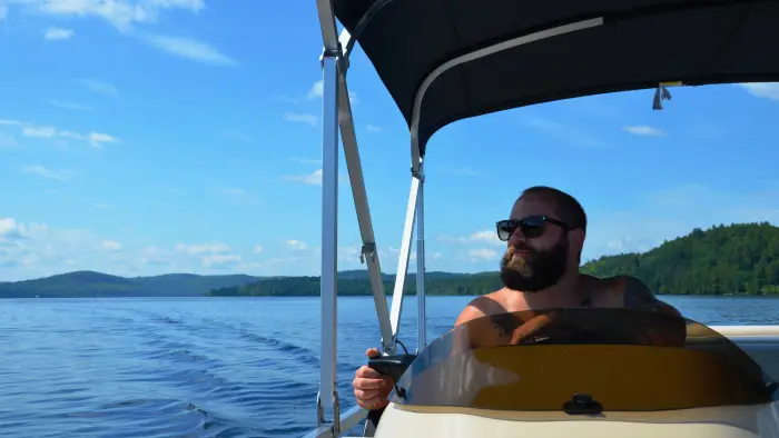 A man driving a pontoon boat