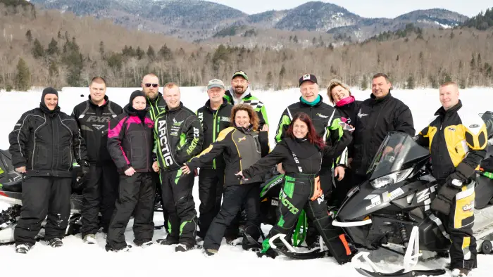 a group of snowmobilers pose for a photo