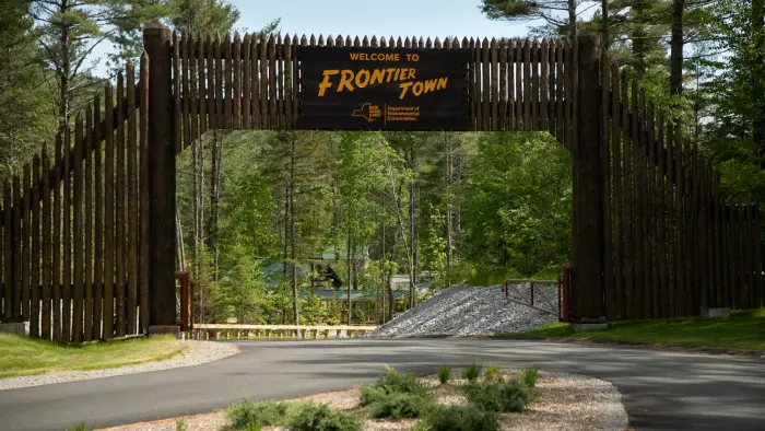 A brown and yellow overhead sign signaling the entrance to Frontier Town.