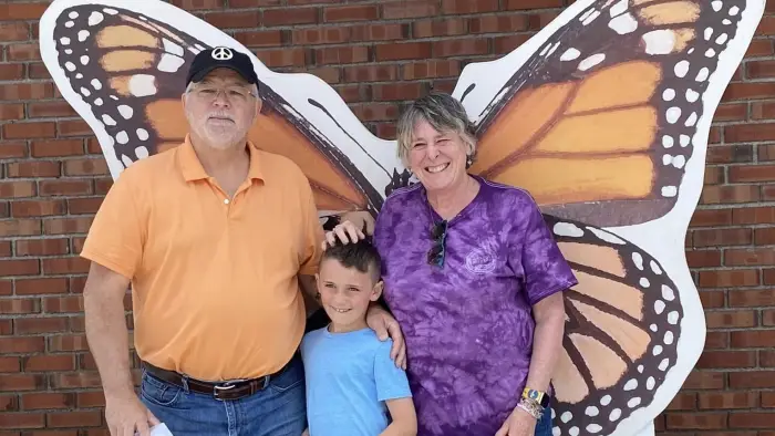 A familt posing in front of the monarch photo prop