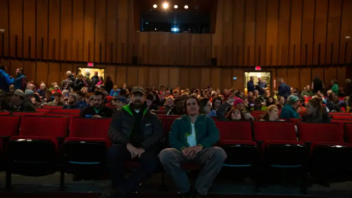 A group of people sitting in the Palace Theatre.