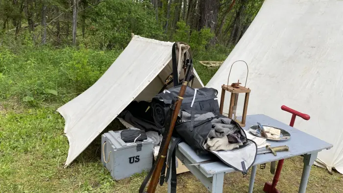 a photo of a canvas tent with related articles used during that time period on display