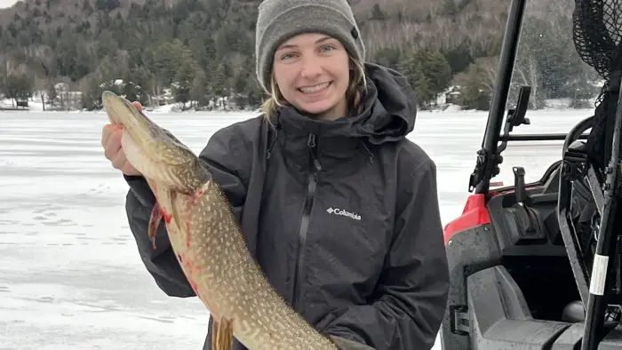 Woman holding a large fish she caught in fishing derby