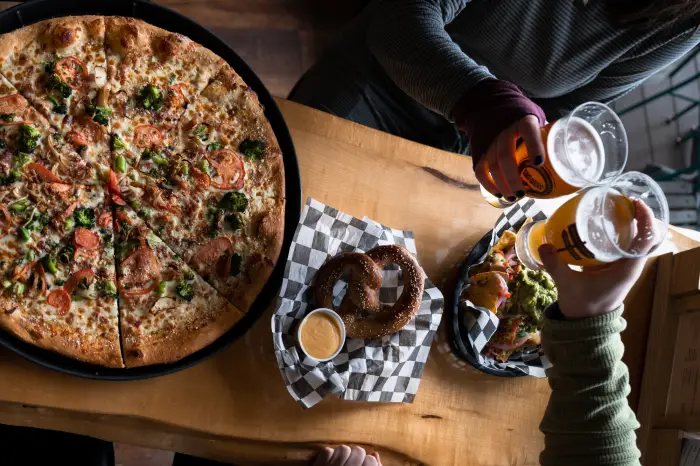 A table spread of pizza&#44; pretzel&#44; and beer