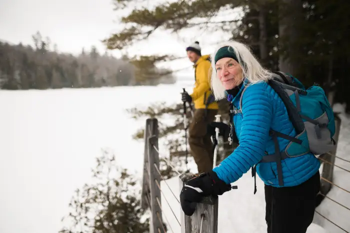 A group looks out to a frozen lake in winter.