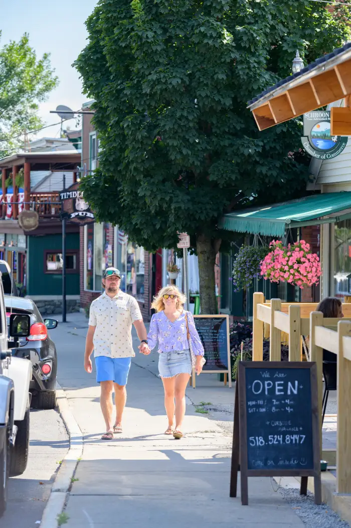 A man and woman shop on a bright main street.