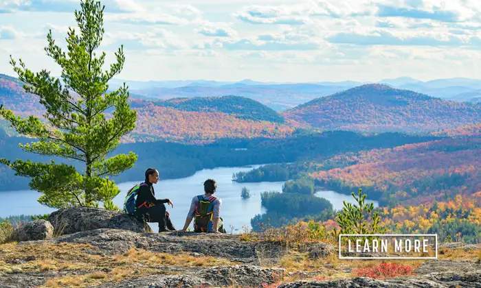 A couple takes in the view from a mountaintop.