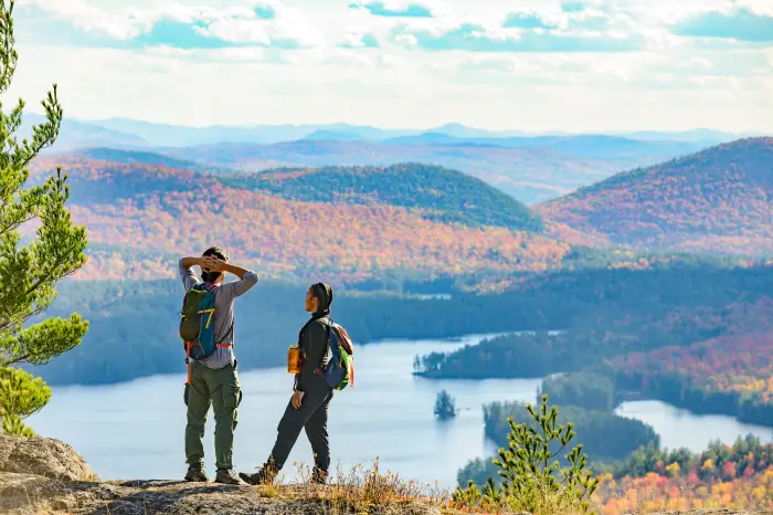 Couple stands at the top of the Treadway Mountain trail with fall scenery.