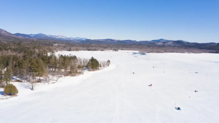 An aerial view of Schroon Lake with fishing shanties on the ice.
