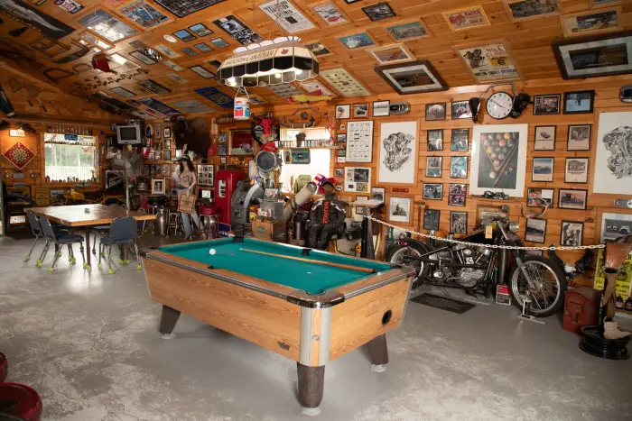 A bar room with a pool table and decorations on the walls.