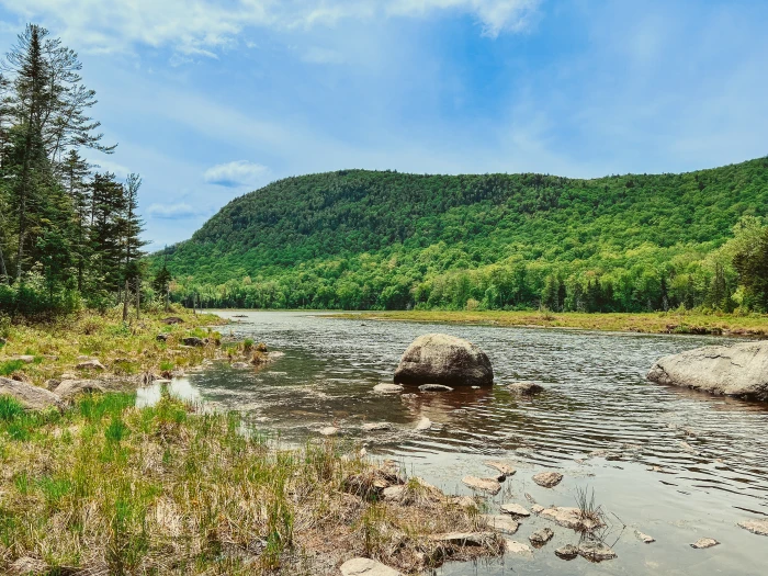 A panorama of a pond with a short&#44; flat mountain in the background.