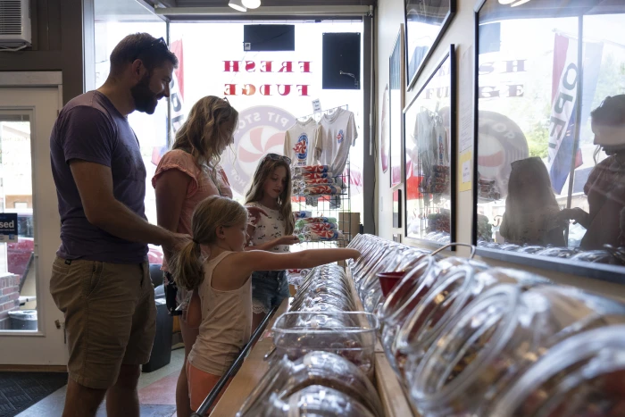 Two adults and two children shopping in an old-fashioned candy store.