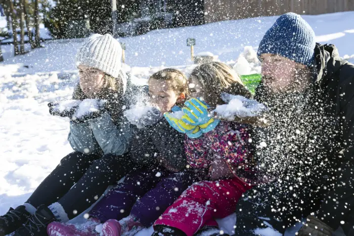 A family blows snow in the air