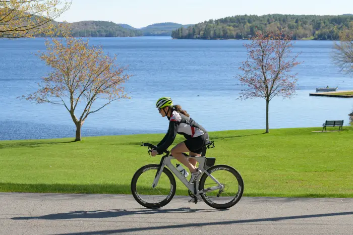 A cyclist rides past Schroon Lake on Leeland Avenue.