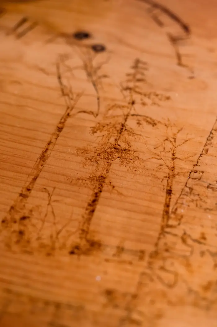 Etchings of trees decorate the surface of a wooden bar
