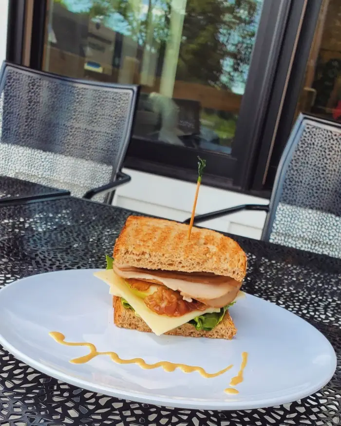 A hearty toasted sandwich sits on an outdoor table.