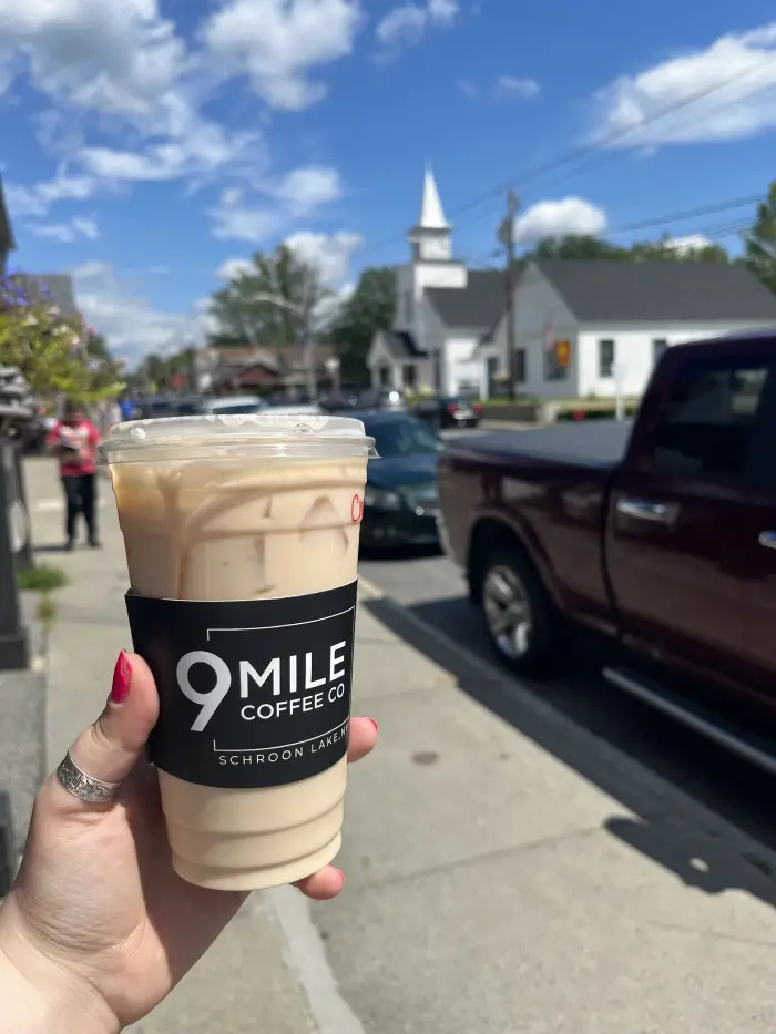 Holding up a cup of coffee from 9 mile coffee