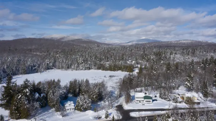 Aerial view of the Inn at Santanoni with snow and blue skies.