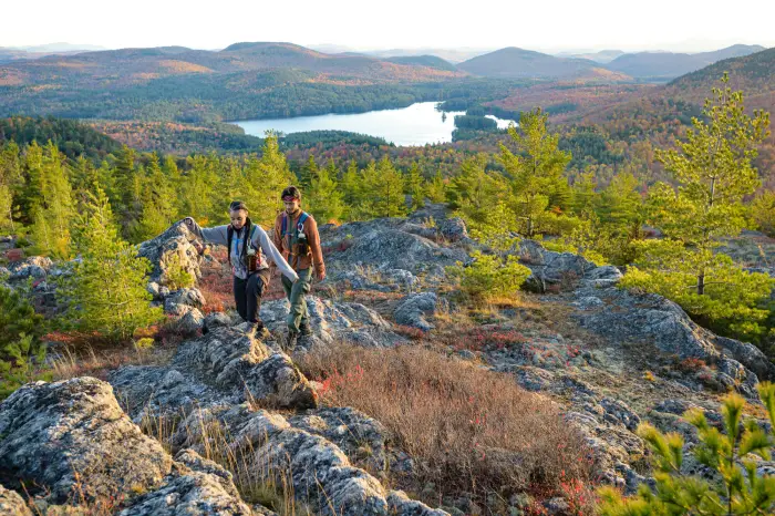 Two people walking on a rocky summit