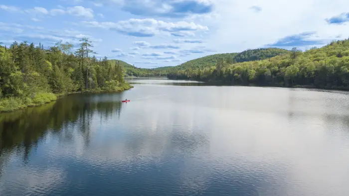 A canoe paddles through a giant lake.