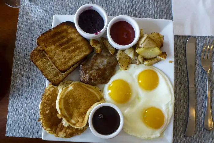 A plate full of breakfast food&#44; including eggs&#44; pancakes&#44; and toast.