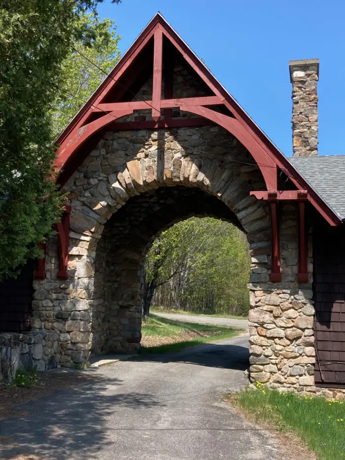 An old stone carriage house with a gravel road underpass.